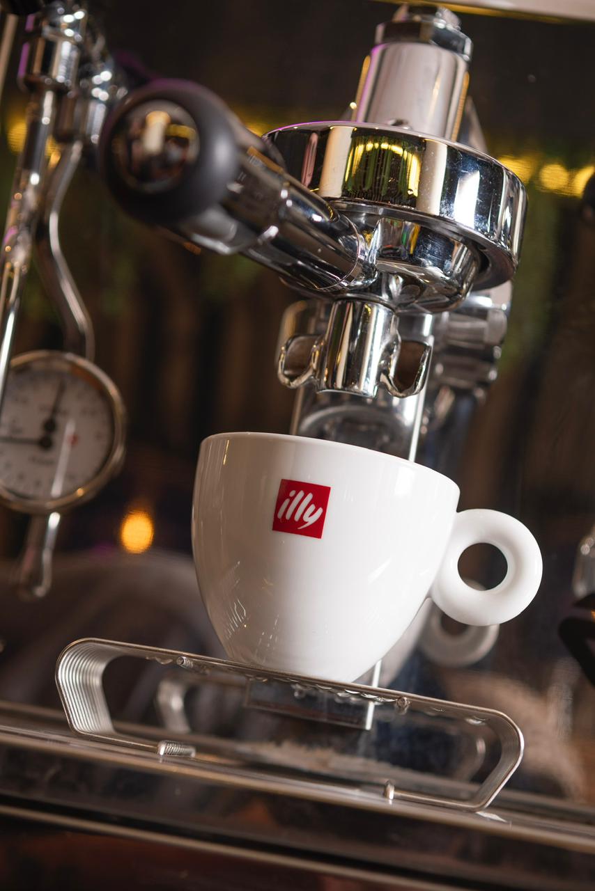 Espresso recién extraído en una taza illy en la barra de café de Shaka.
