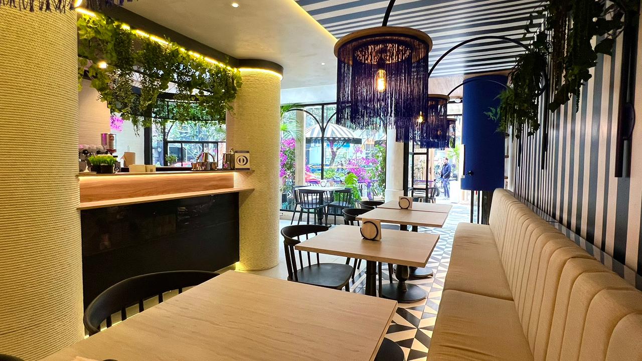 Bar interior con candelabro púrpura y ambiente tropical.